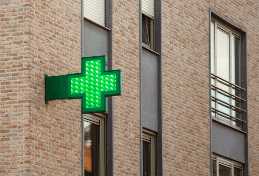 Façade d’une pharmacie en centre-ville sur rue commerçante avec accès tram