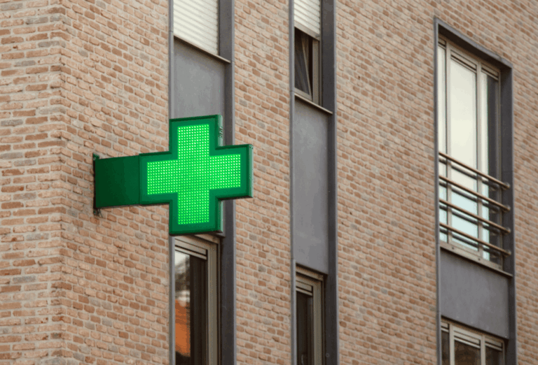 Façade d’une pharmacie en centre-ville sur rue commerçante avec accès tram