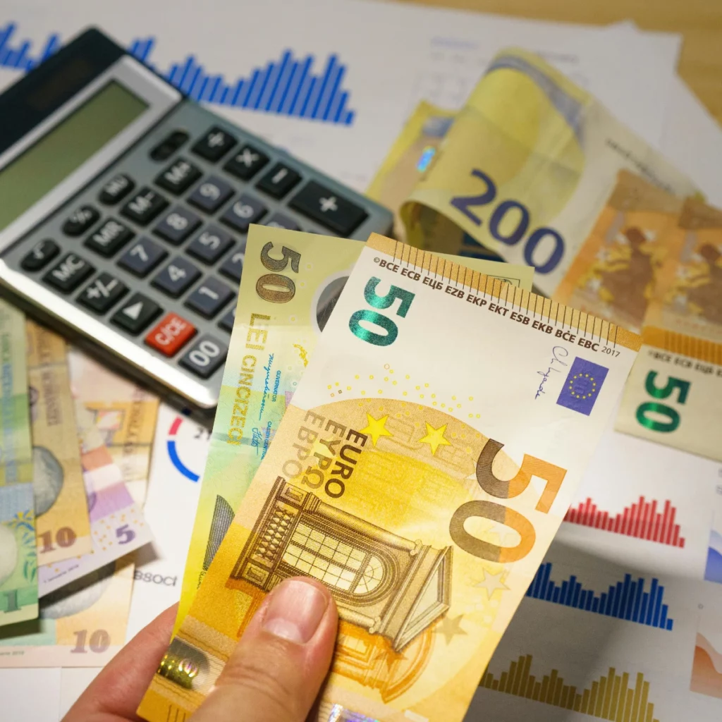 Billets en euros, calculatrice et graphiques illustrant une levée de fonds pour financer le développement d’une entreprise